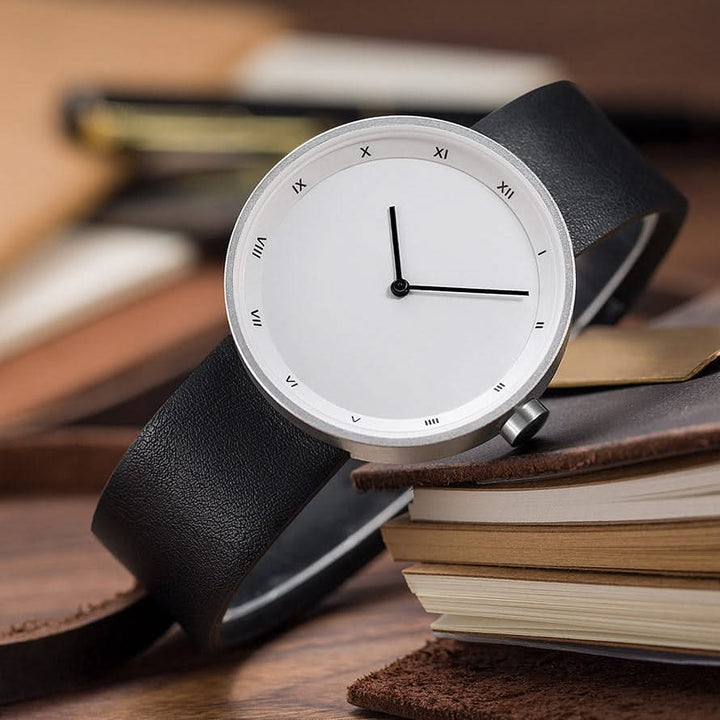 Versatile unisex quartz watch with a clean white dial and a dark, minimalist leather strap.