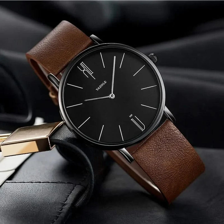 Unisex minimalist watch featuring a sleek stainless steel case and a classic black leather band.
