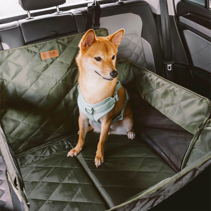 Dog enjoying a ride on a Pet Car Back Seat Extender, safe and comfortable travel gear