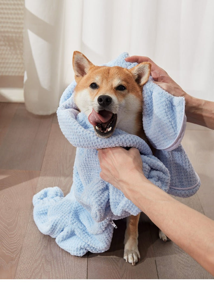 Dog wearing a blue full-body absorbent bathrobe with hood, ideal for post-bath pet care.