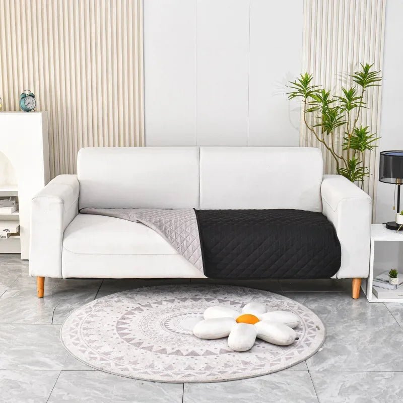 Waterproof pet incontinence blanket draped over a sofa, protecting furniture from spills