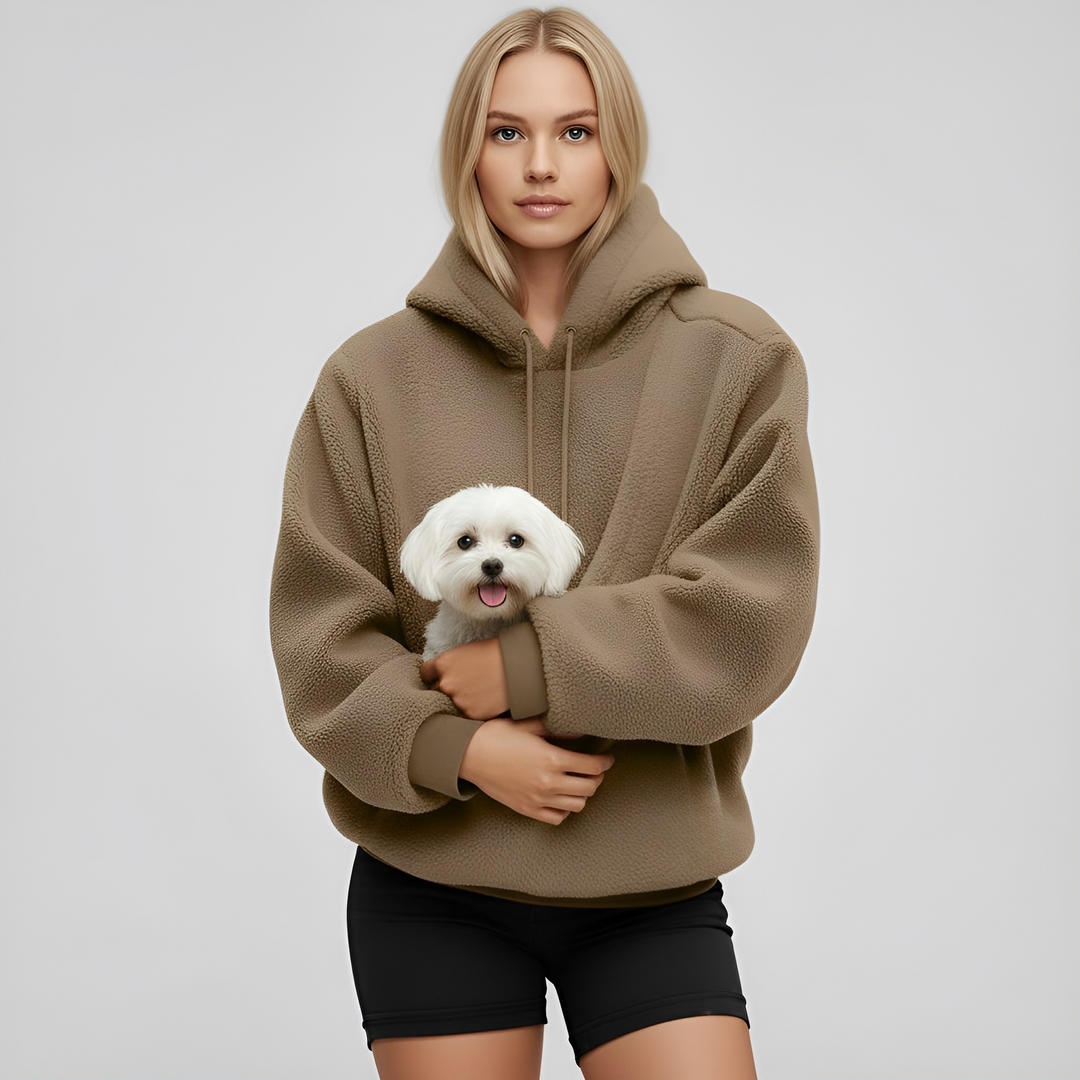Happy owner wearing a unisex pet carrying hoodie, snuggling with their pet, highlighting comfort and warmth.