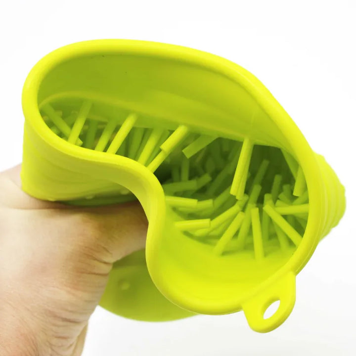 Hand holding a unisex pet silicone massage brush, demonstrating its comfortable grip and use