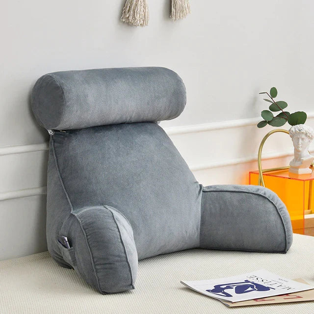 Unisex plush reading bed pillow with arms & back support for cozy relaxation.