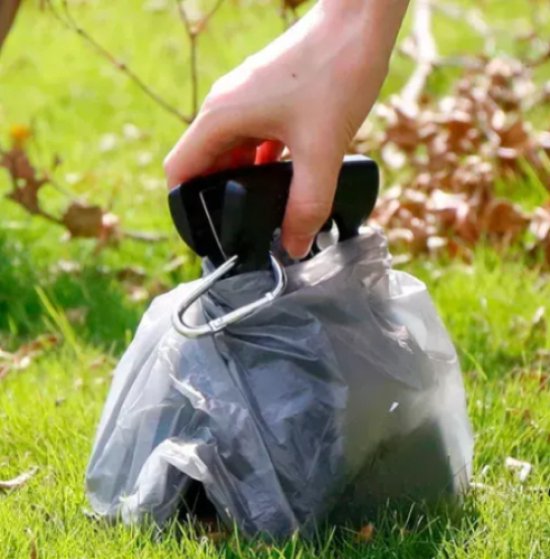 Compact outdoor pet waste disposal tool with ergonomic handle, ensures clean and easy pickup.