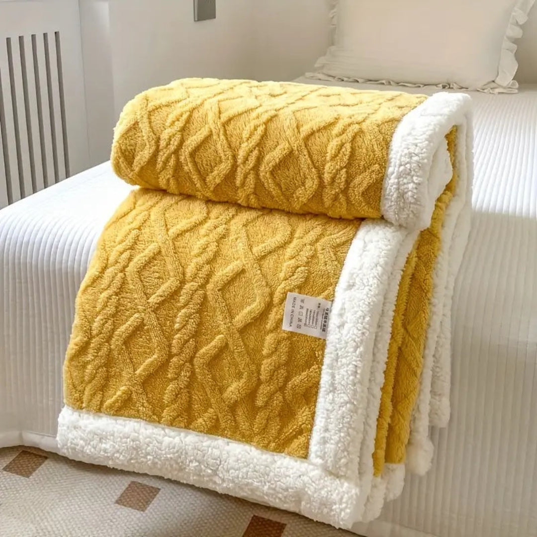 Unisex reversible sherpa fleece blanket in a neutral color, perfect for cozying up on the sofa.