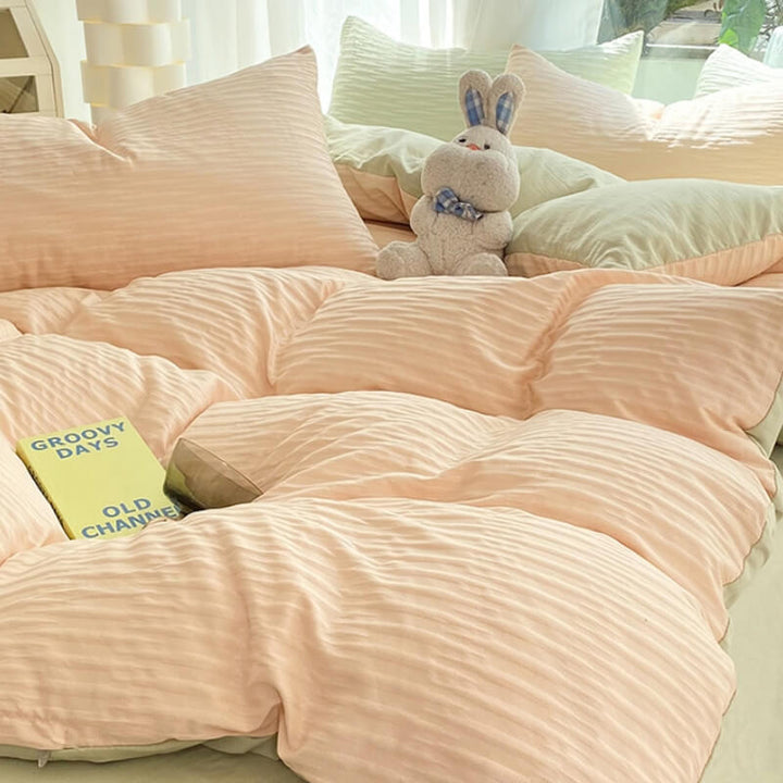 Complete set of solid color seersucker bedding, including duvet cover and pillow shams, in light gray.