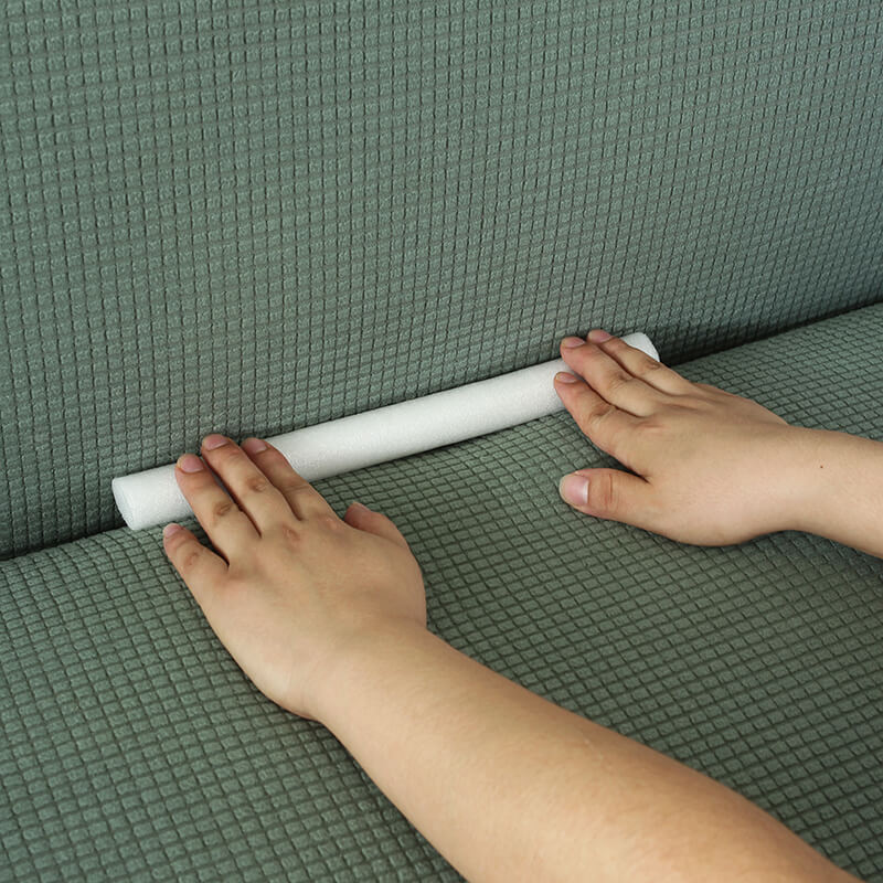 Flexible foam sofa cover grippers inserted into couch cushions, ensuring slipcover stability, upholstery care