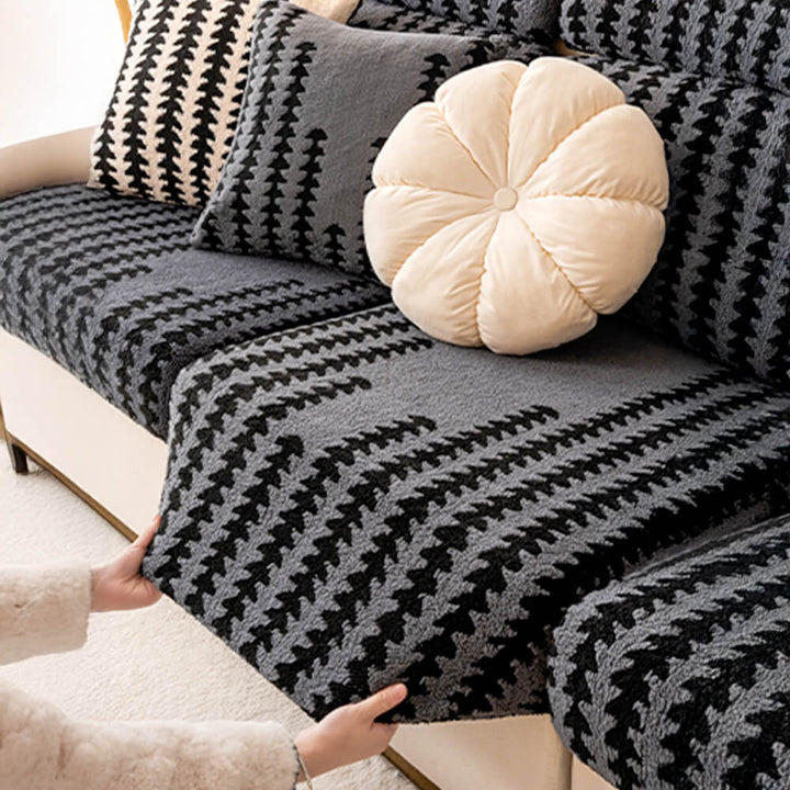 Close-up of herringbone pattern on a gray stretch sofa slipcover, cozy home essential