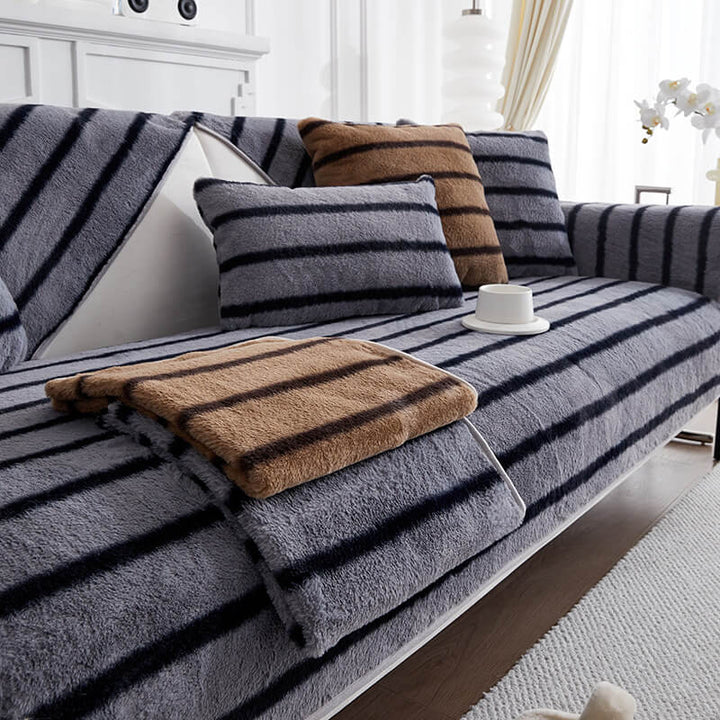 Full view of a living room sofa with a striped faux rabbit fur protector, modern decor