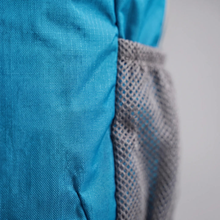 Hiker wearing a spacious unisex tactical rucksack on a mountain trail, ready for adventure & camping.