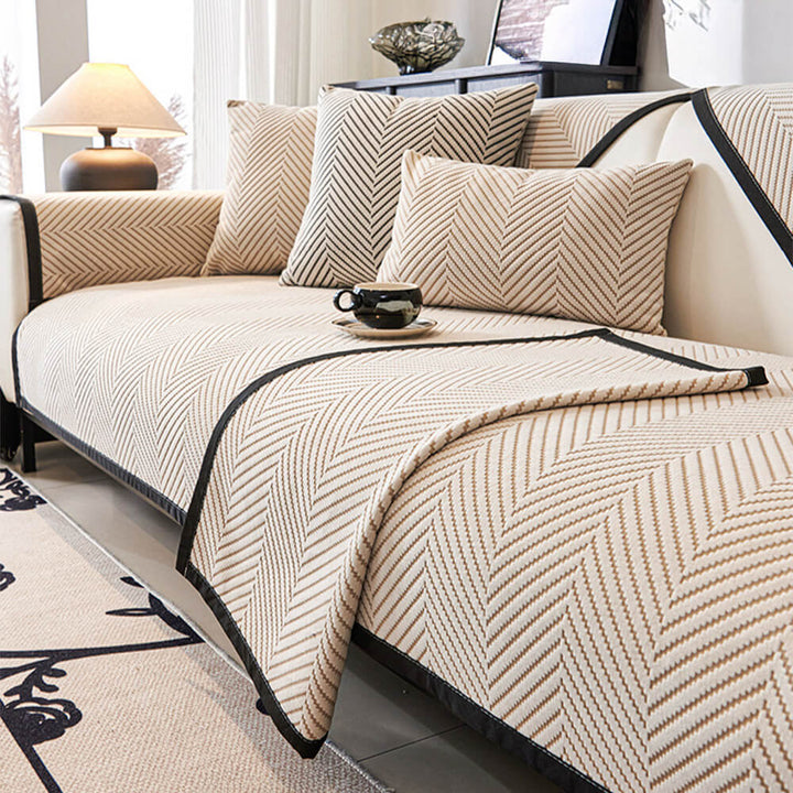 Lifestyle shot of a comfortable sofa with a unisex two-tone herringbone fleece couch cover