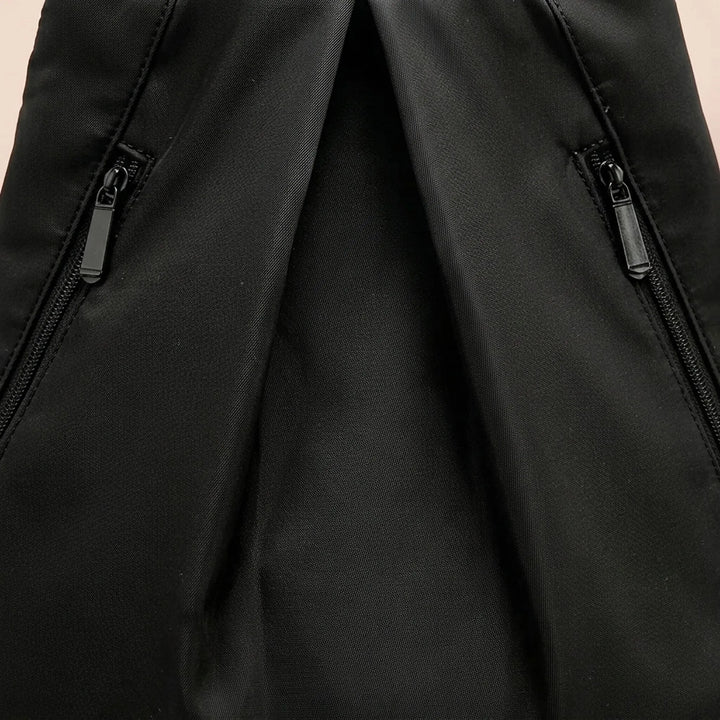 Sleek black polyester waterproof backpack, a durable and practical daypack for travel, swim, and hiking.