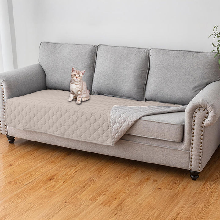 Lifestyle image of a dog relaxing on a diamond quilted pet protector couch cover, showing durability and comfort