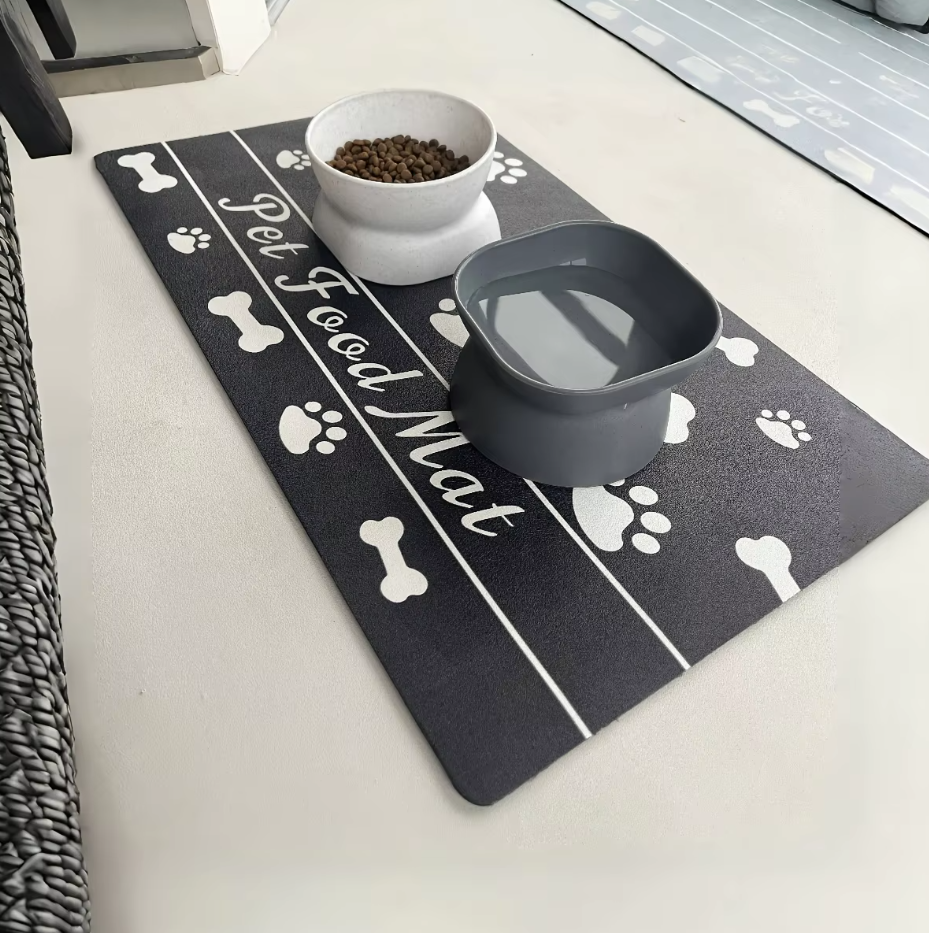 Black pet feeding mat, waterproof and non-slip, keeps floors clean for dog and cat bowls.