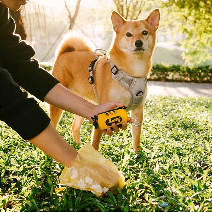 Portable pet waste bag dispenser made of durable waterproof nylon, perfect for outdoor walks