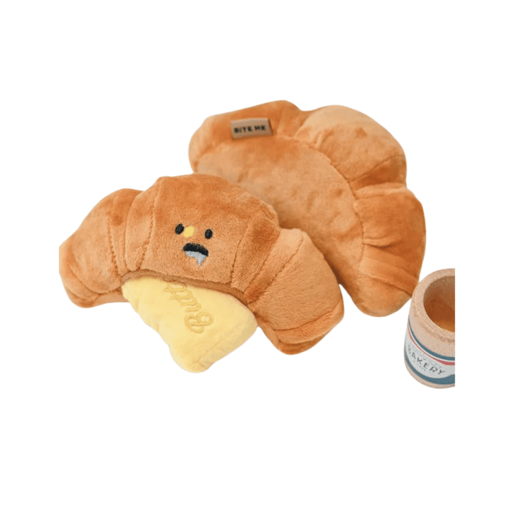 Croissant dog toy with squeaker, soft yellow plush material, ideal for pet chewing and entertainment.