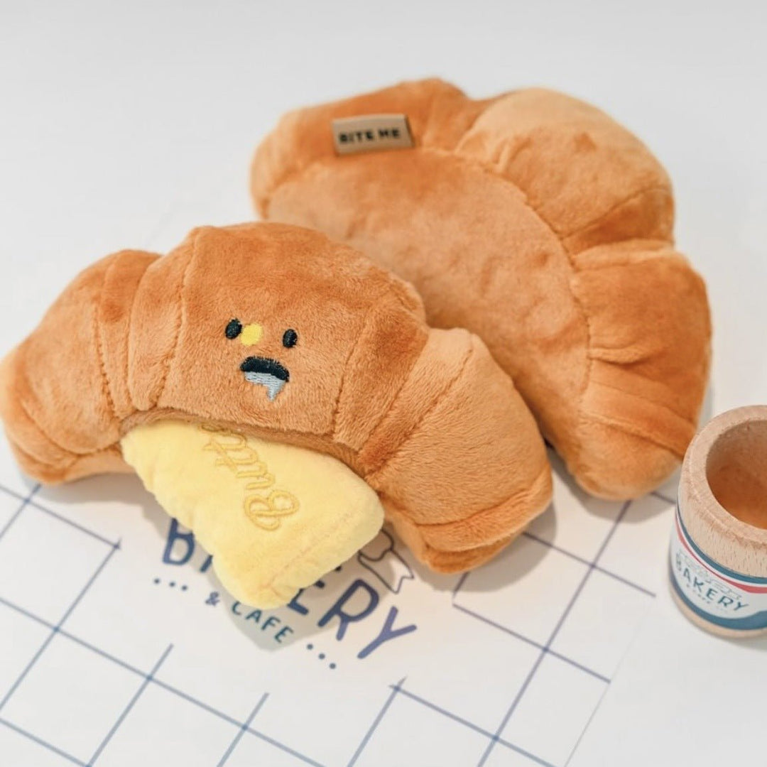 Cute yellow croissant-shaped squeaky toy for dogs, a fun and durable pet accessory for play.