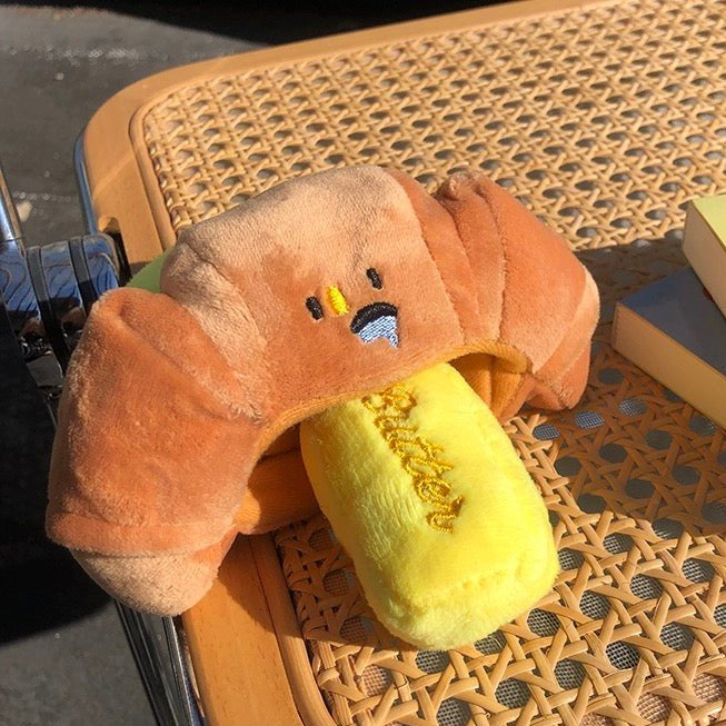 Durable yellow croissant squeaky toy, perfect for pets, offering hours of fun and chewing.