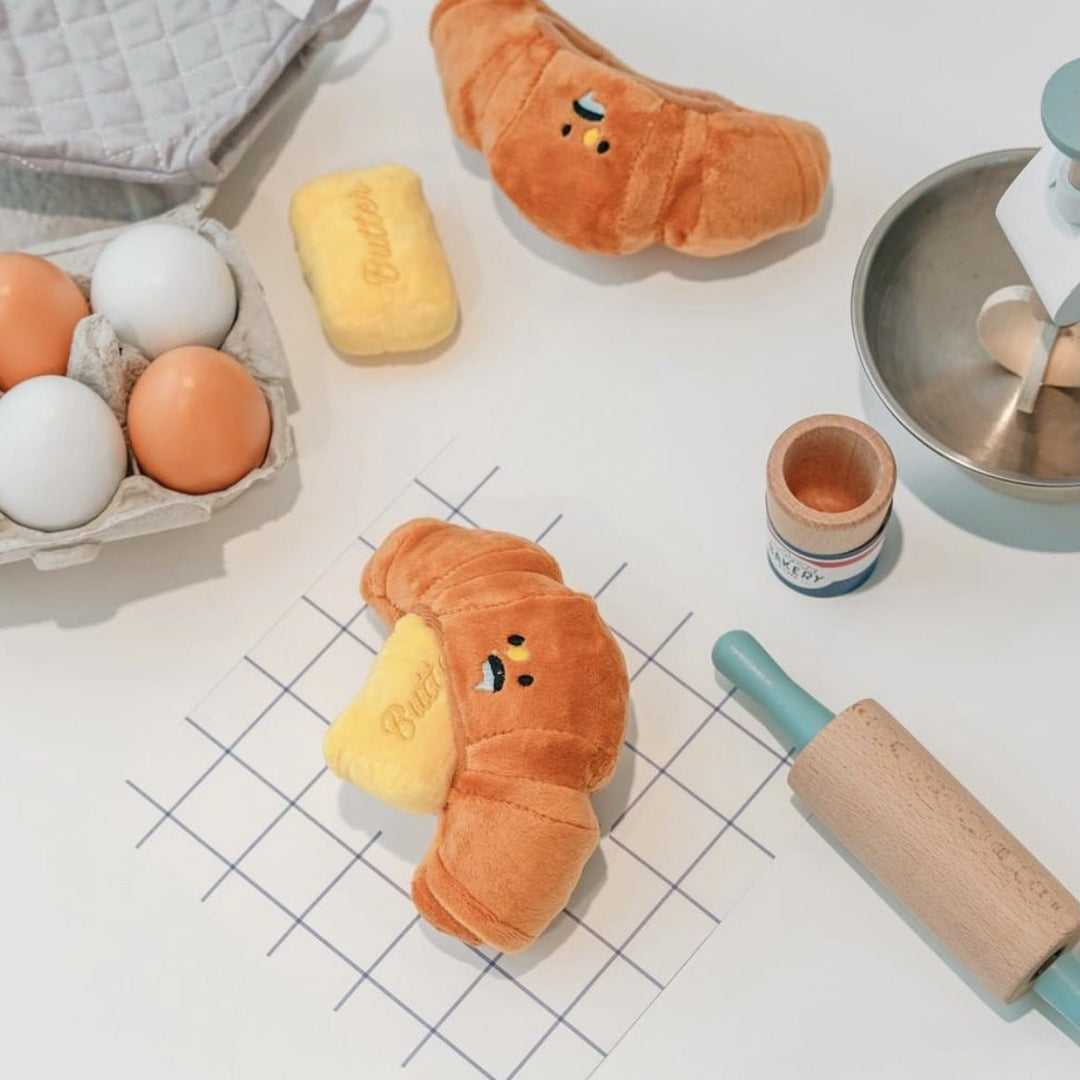 Interactive croissant dog toy, yellow plush, a squeaky pet accessory for playful animals.