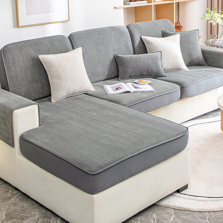 Light beige universal stretch couch cover in herringbone pattern, fitting a three-seater sofa snugly