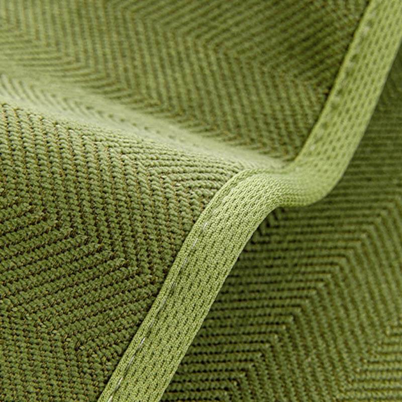 Detail view of the elasticized hem of a universal stretch chenille herringbone couch cover