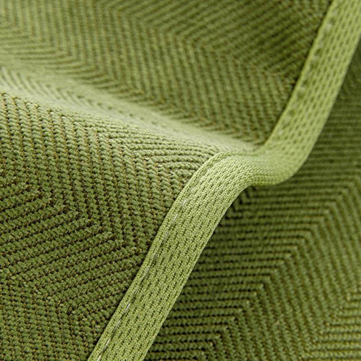 Detail view of the elasticized hem of a universal stretch chenille herringbone couch cover