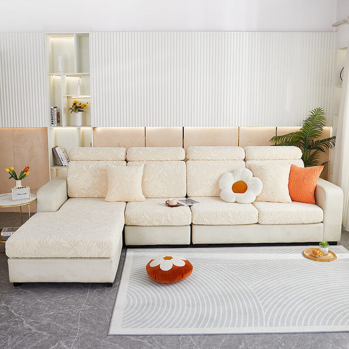 Elegant stretch velvet floral sofa protector draped over a L-shaped couch, sophisticated design