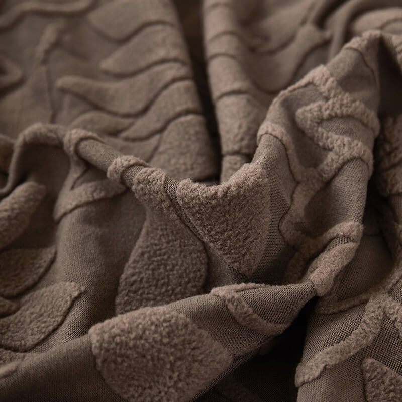 Corner of a couch with a fitted velvet floral slipcover, soft and stretchable fabric