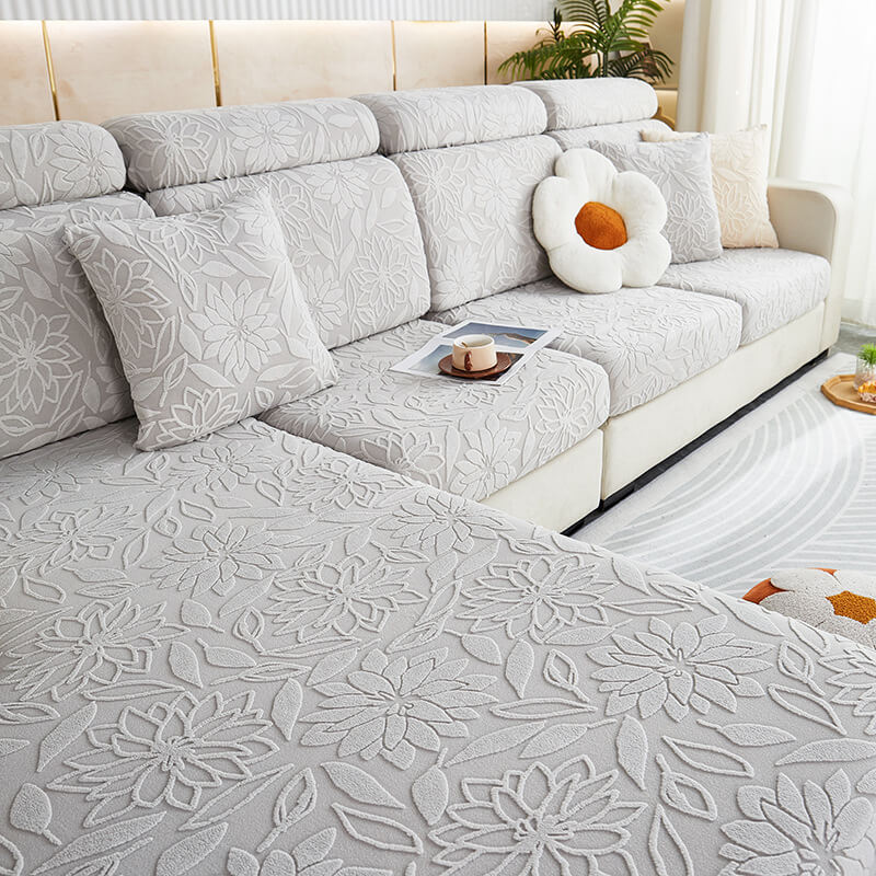 Full view of a living room sofa dressed in a velvet stretch floral couch cover, elegant decor