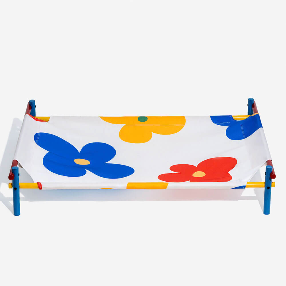 Modern pet furniture: elevated dog bed with colorful summer print fabric and sleek aluminum frame.