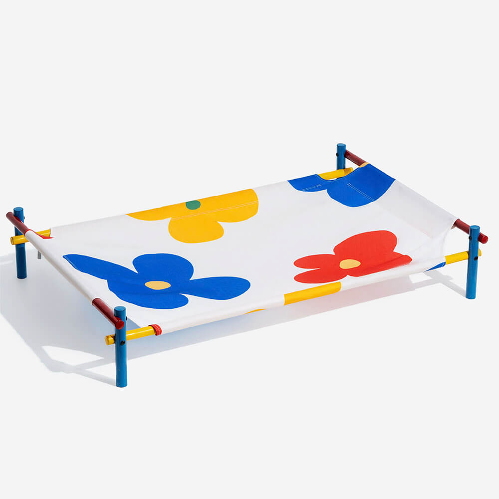 Outdoor-ready elevated dog bed in a vibrant summer design, supported by a durable aluminum frame.