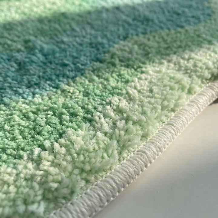 Plush comfort gradient area rug with a soft pile and non-slip backing, ideal for bedroom or bathroom.