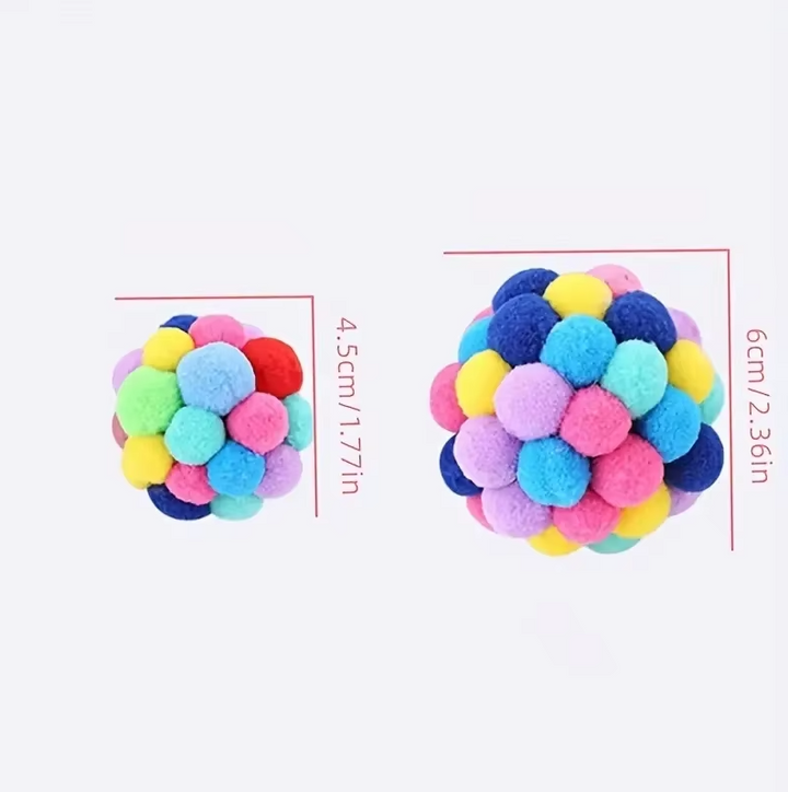 Close-up of a soft, fluffy pompom cat toy, brightly colored and ready for interactive play.