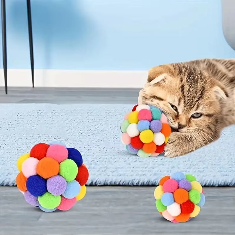 Bright vibrant pompom cat toy ball with a blurred background, perfect interactive feline play.