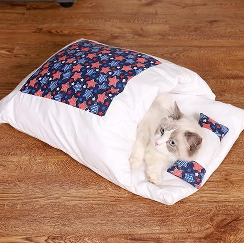 A cat peeking out from a cozy cat sleeping bag, emphasizing the pet comfort design