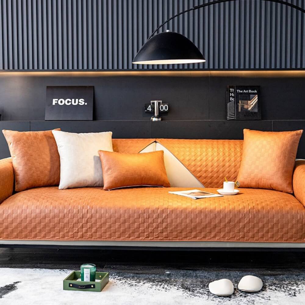Water-resistant faux leather sofa cover with elastic straps, ensuring a snug fit on various couch styles.