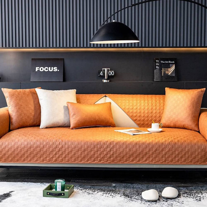Water-resistant faux leather sofa cover with elastic straps, ensuring a snug fit on various couch styles.