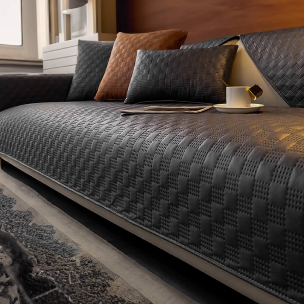 Contemporary home decor featuring a sleek, waterproof faux leather couch cover in charcoal grey.