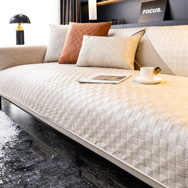 Black water-resistant faux leather sofa cover draped over a modern couch, enhancing home decor while protecting.