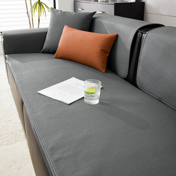 Water-resistant pet-friendly sofa protector cover in a neutral color, draped neatly over a couch.