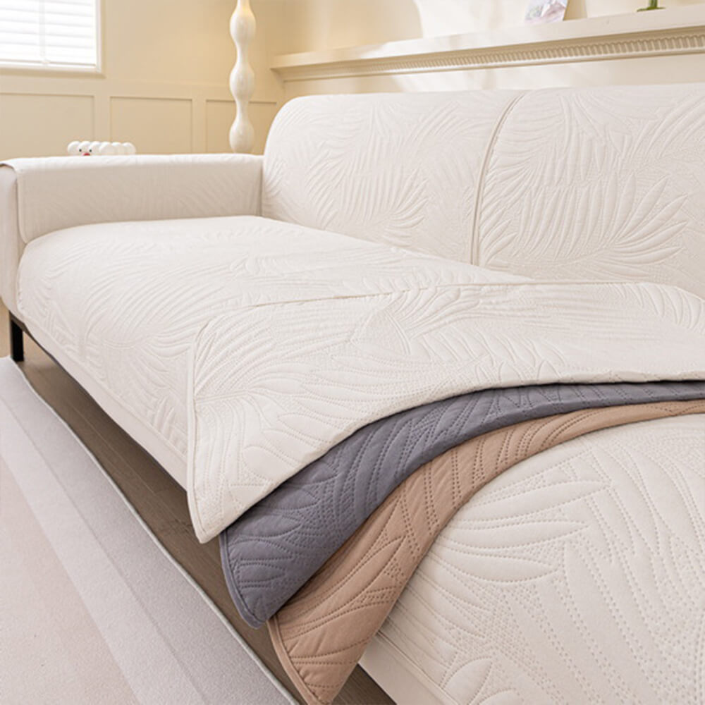 Quilted water-resistant sofa cover with secure non-slip backing, enhancing home decor and furniture protection