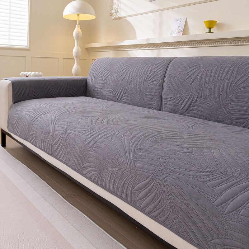 Sectional sofa covered with a water-resistant, non-slip, quilted couch cover in a modern design