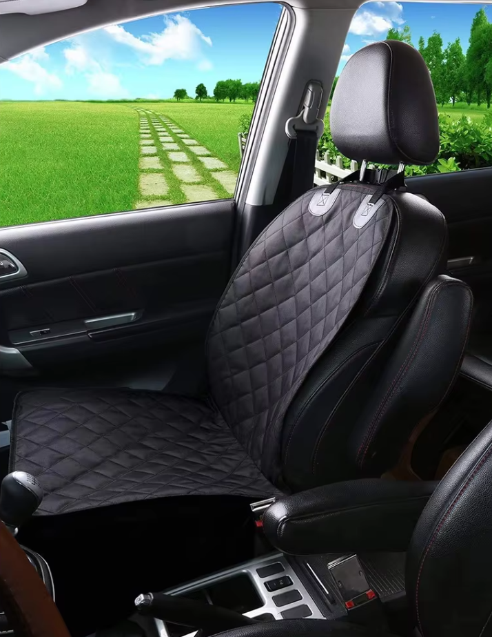 Dog enjoying a ride on a beige waterproof front car seat cover, ensuring clean travel