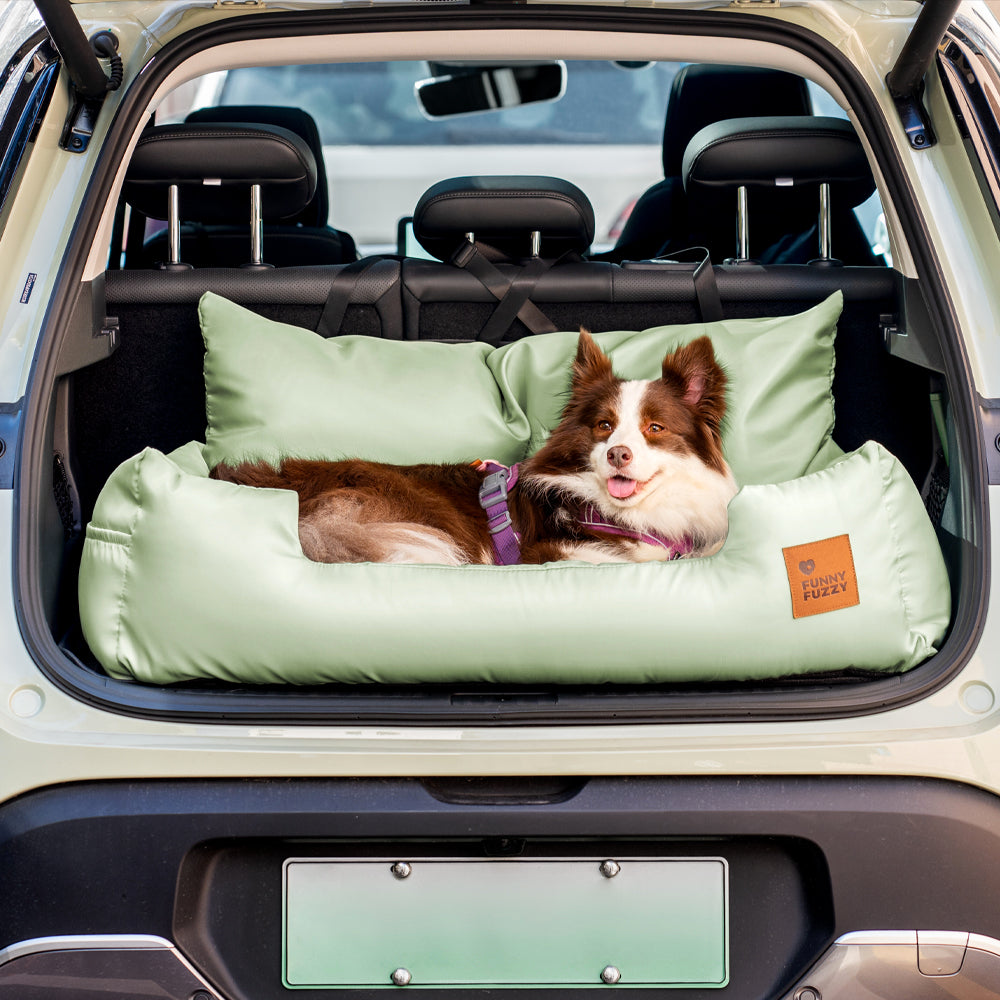 Medium dog sniffing the comfortable bolster of a waterproof car seat bed