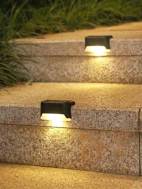 Waterproof outdoor solar LED deck light illuminating a wooden deck at dusk, energy efficient design