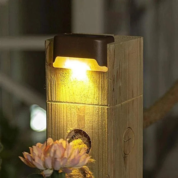 Energy efficient solar LED deck light shown mounted on a fence post, enhancing garden decor