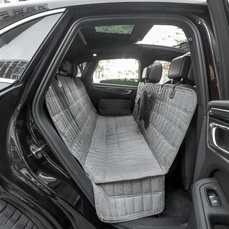 Durable pet car seat cover forms a protective hammock in the back seat, great for pet travel safety.