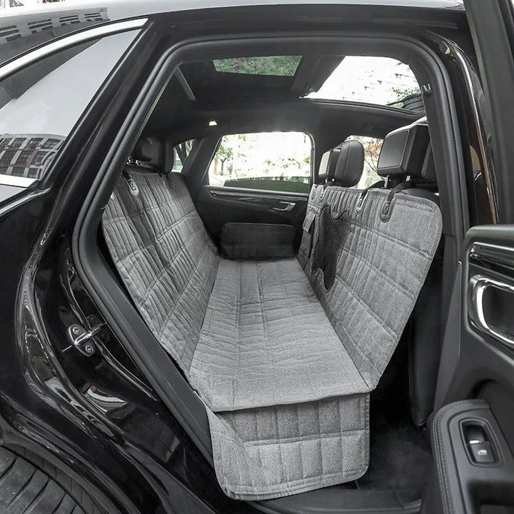 Durable pet car seat cover forms a protective hammock in the back seat, great for pet travel safety.