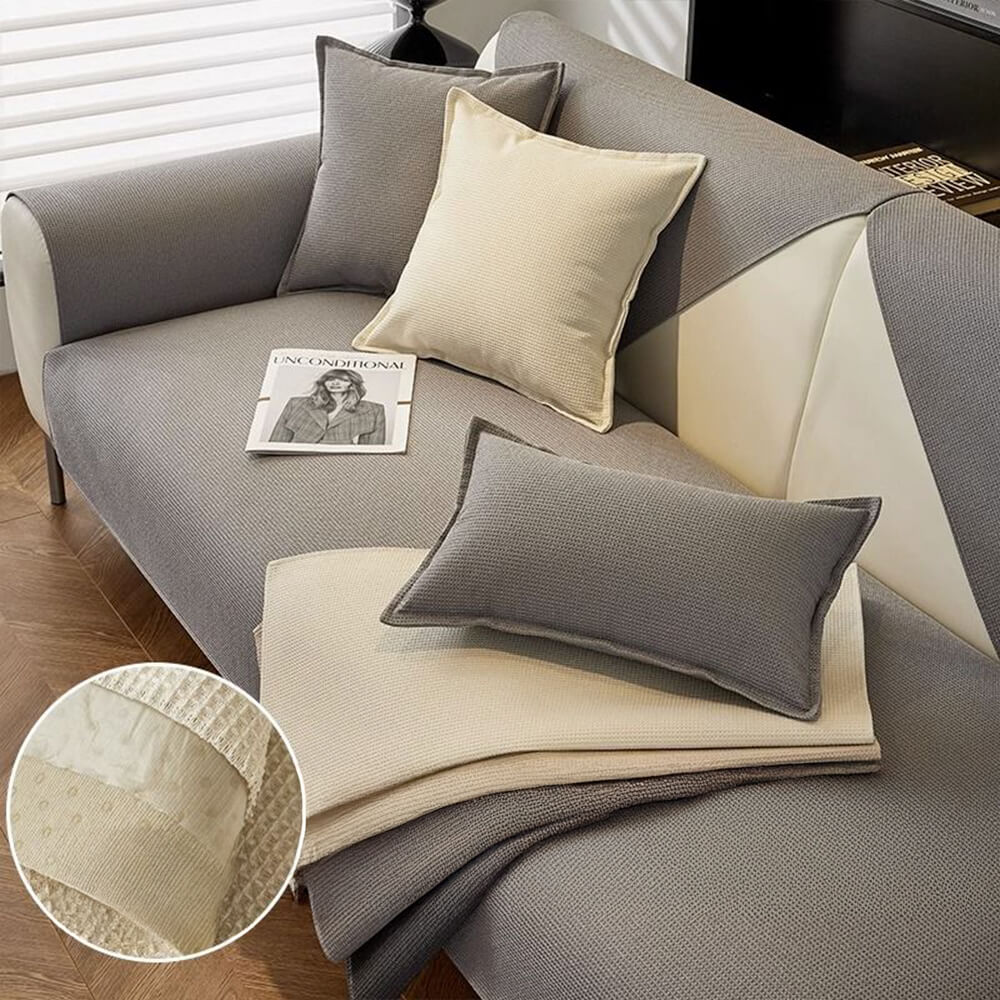 Waterproof quilted sofa cover in gray, protecting a three-seat couch from pet stains. Pet friendly.